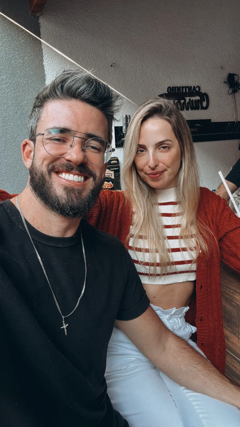 O casal aconchegado em um sofá, sorrindo