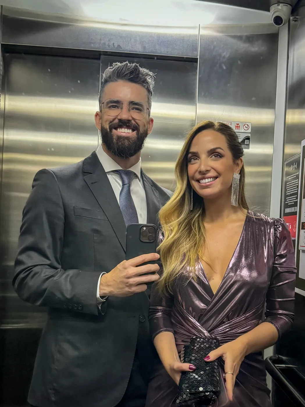 Agnes e Thiago arrumados, em uma selfie no espelho do elevador