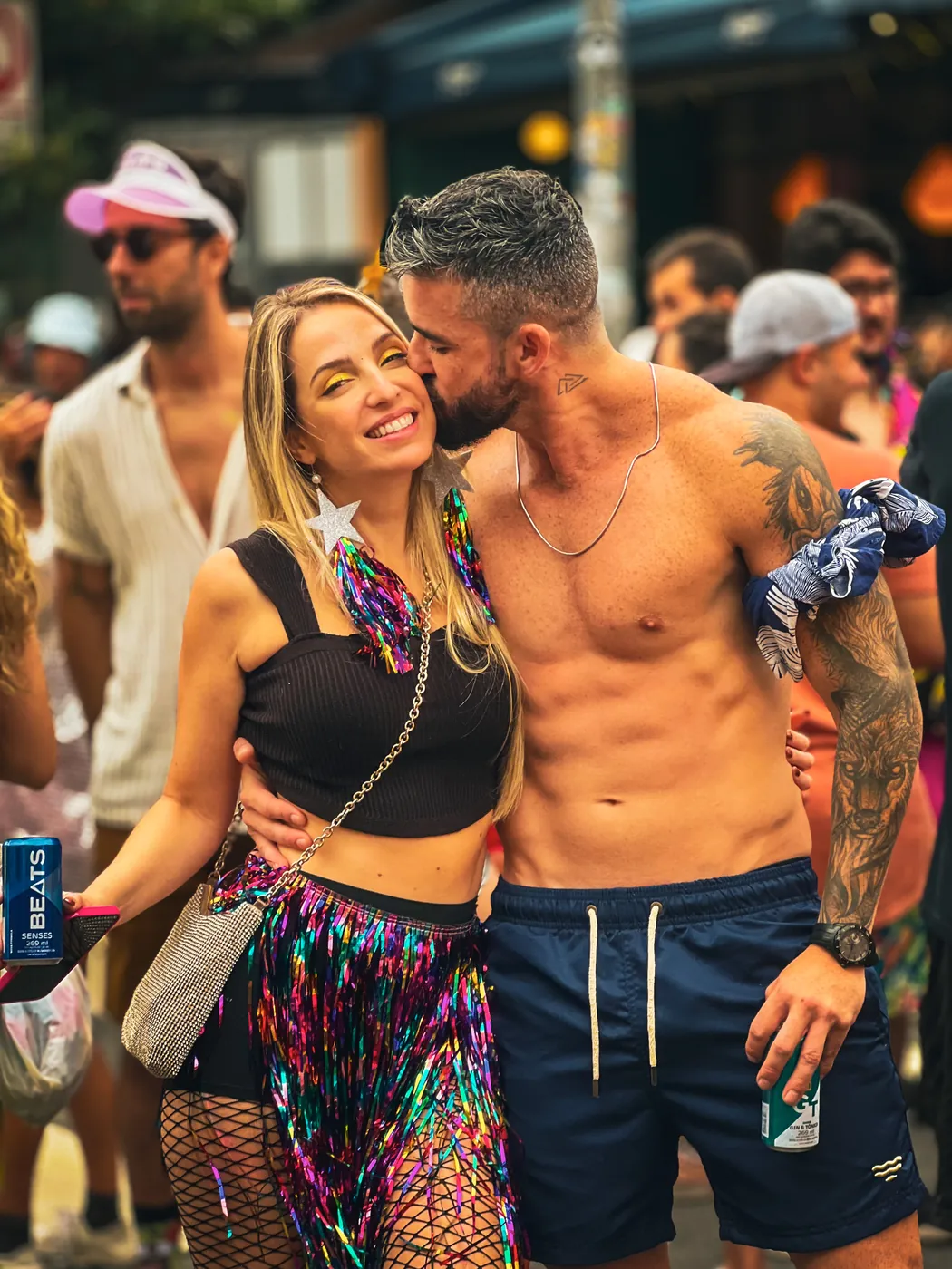 O casal abraçado em um bloco de carnaval colorido