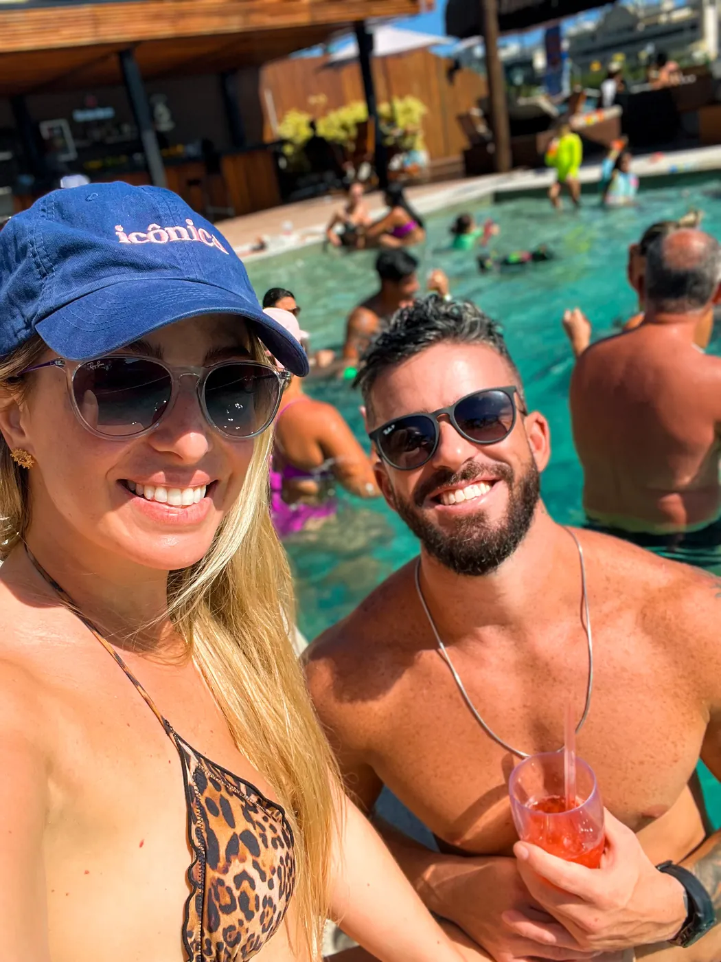 Agnes e Thiago em uma selfie à beira da piscina no sol