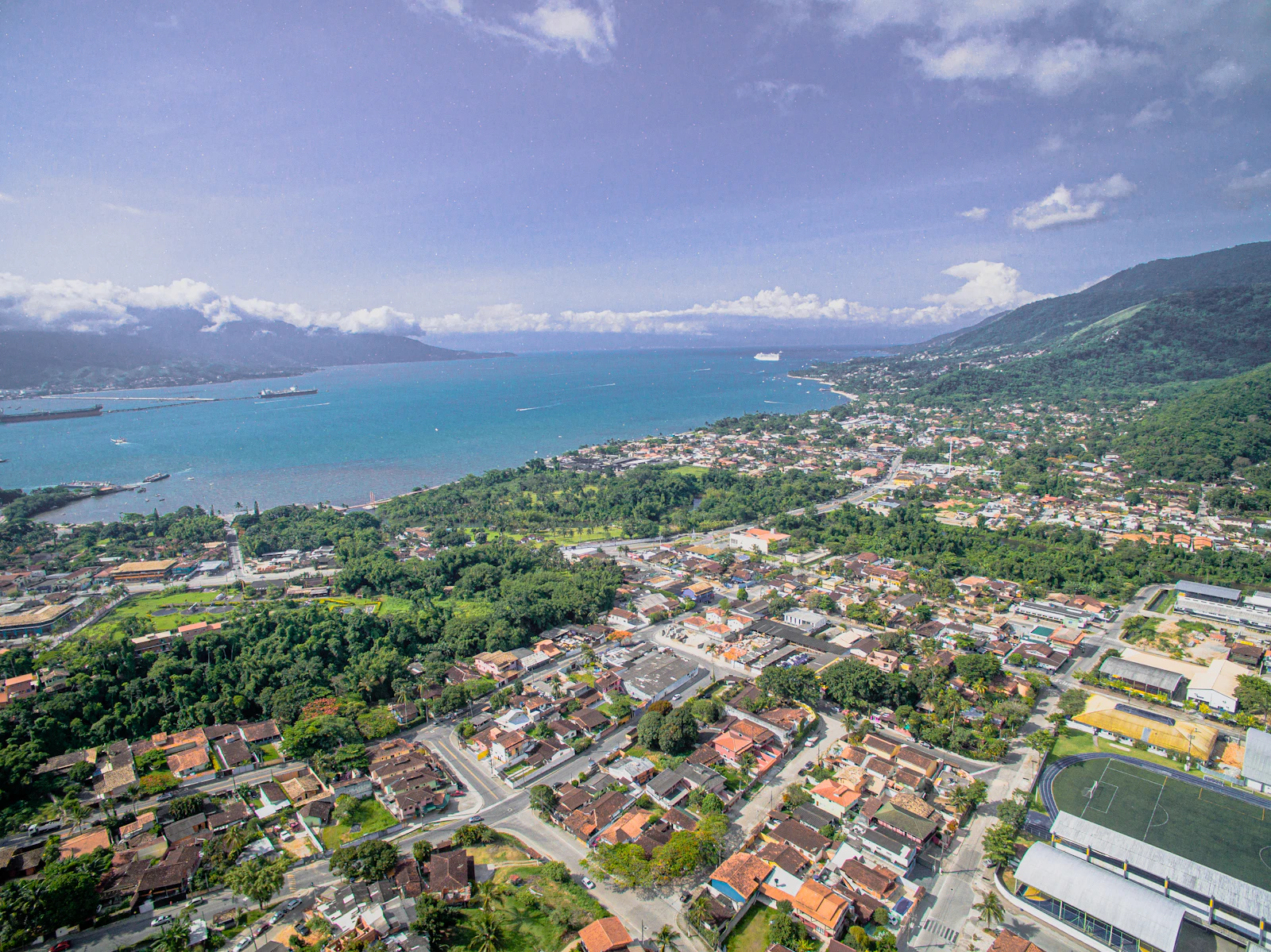 Vista aérea de São Sebastião, o canal e Ilhabela ao fundo, com os telhados coloniais